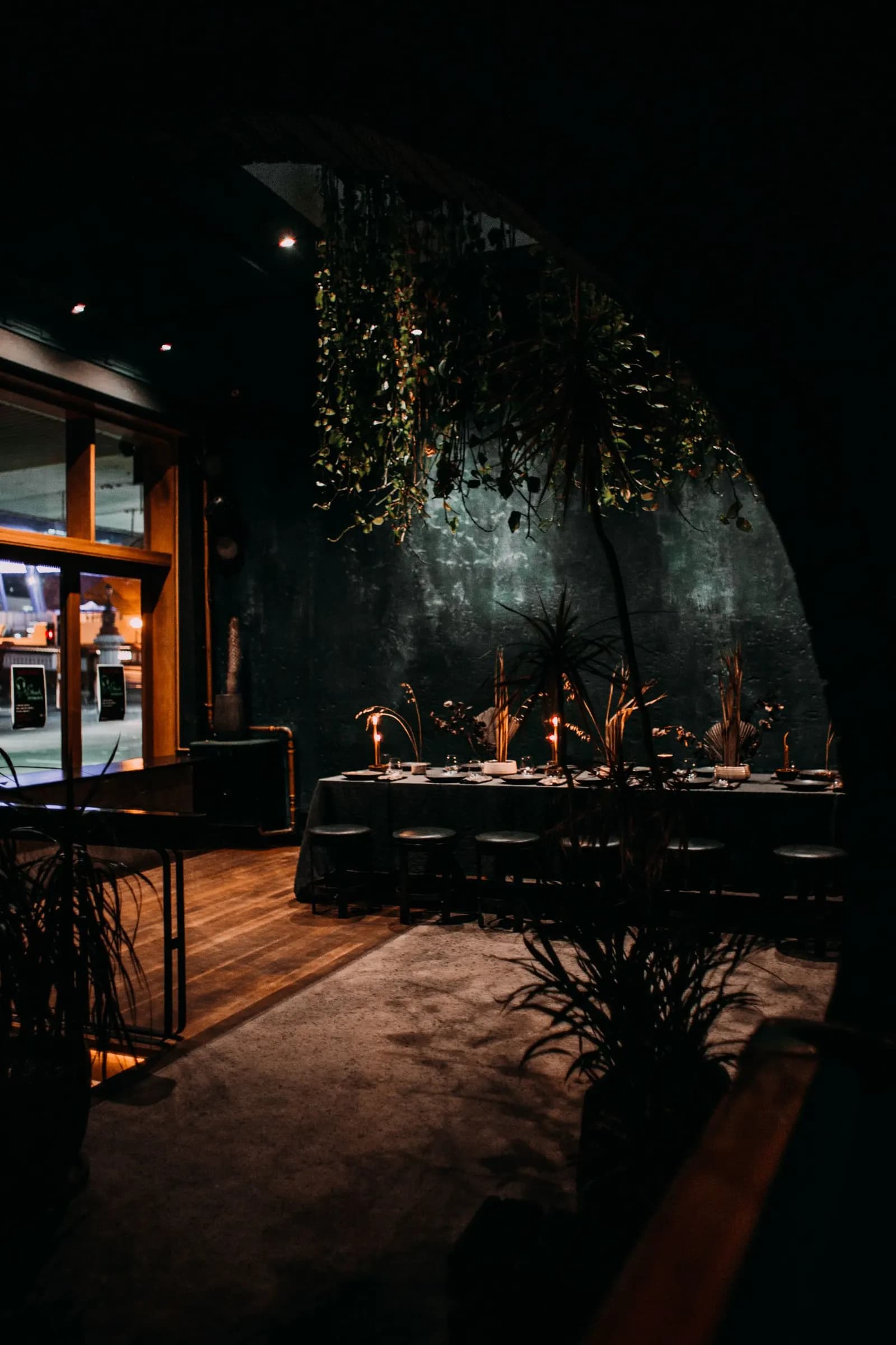 Interior de un restaurante en penumbra con velas encendidas sobre las mesas